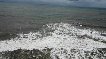 A view of the ocean from above with waves crashing into the shore video