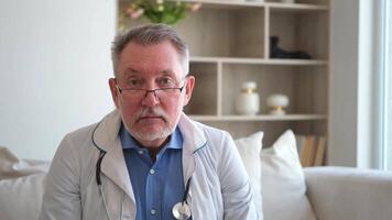 Senior man doctor talk on call have consultation with patient look at camera webcam. Professional senior mature healthcare expert examining patient online. Healthcare concept. Webcamera view video