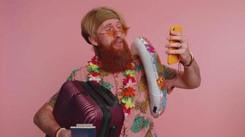 Traveler blogger man in sunglasses with luggage taking selfie on smartphone record make call video