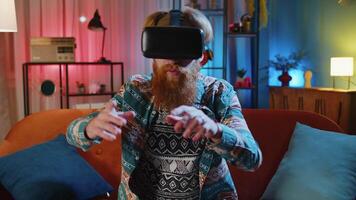 Man using virtual reality futuristic technology headset to play simulation 3D game at home video