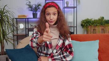 Preteen girl smiling, pointing to camera, choosing lucky winner, indicating inviting approve at home video