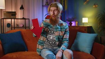 Upset hippie man showing red arrow pointing down, concept of downgrade bankruptcy money fail, fall video