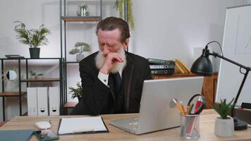 Inefficient tired lazy business man working sleeping on laptop computer with eyes stickers on face video