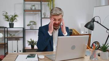 Inefficient tired lazy business man working sleeping on laptop computer with eyes stickers on face video