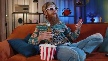 Man sitting on couch eating popcorn and watching interesting TV serial, sport game online at home video