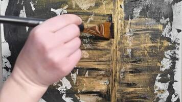 Artistic hand painting abstract gold patterns on dark canvas with skillful brush techniques in timelapse. video