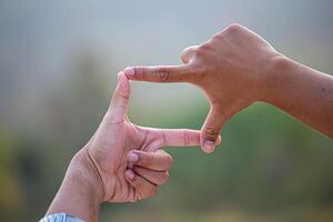 Hands of person making frame distance or symbol in nature. photo
