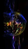 A sphere of star-shaped multi-colored particles, sparkling in space, shimmering in waves from a palette of different colors. video