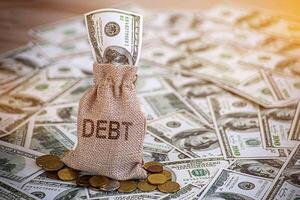 Financial debt concept. A man hand on stack of coins and money bag showing about debt. photo