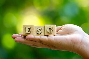Concept of sustainable corporate development, wood block and future environmental protection and ESG modernization using renewable resource technology to reduce pollution. carbon emissions in the air photo