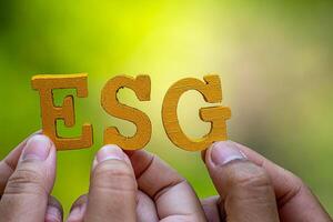 ESG concept of environmental, social, and governance. Sustainable corporation development. words ESG on a wood block on the environmental background.Idea for sustainable organizational photo