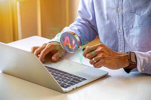 man using laptop with magnifying glass on it photo
