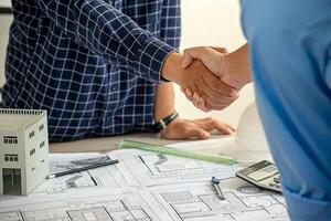Architect and engineer construction workers shaking hands after successful collaboration. photo