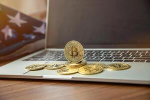national flag of liberia on the keyboard with bitcoin coins on a grey background.concept photo