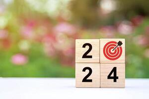 Trend of 2024. Wooden cube with word 2024 with target icon. photo
