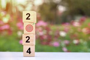Trend of 2024. Wooden cube with word 2024 with target icon. photo