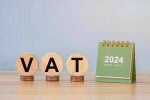 close up stack of coin, tax wooden text block and 2024 small calendar photo