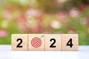 Trend of 2024. Wooden cube with word 2024 with target icon. photo