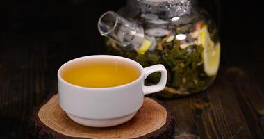 making green tea in a glass teapot with lemon and mint photo