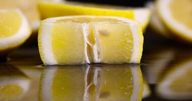ripe sliced lemon and its reflection on a wet table photo