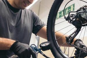anonymous bicycle mechanic inflating the wheel in workshop photo