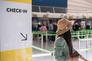 anonymous girl in the check-in line with passport in hand photo