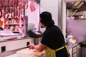 Butcher Seen from Behind Breading Chicken Nuggets with Flour in Butcher Shop photo