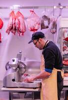 vertical portrait Precision at Work Butcher Operating Meat Cutting Machine photo