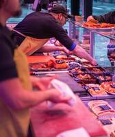 Butcher Serving Prepared Food Order to Customer at Glass Counter photo