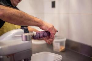 Closeup of Butcher's Hands Stuffing Sausages with Meat Using Machine copyspace photo