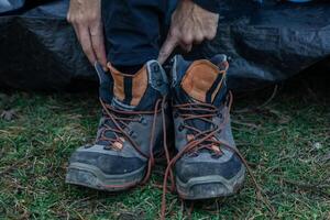Closeup of Man Wearing Dirty Trekking Boots on Grass photo