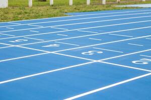 CloseUp of Finish Line with Lane Numbers on Blue Running Track photo