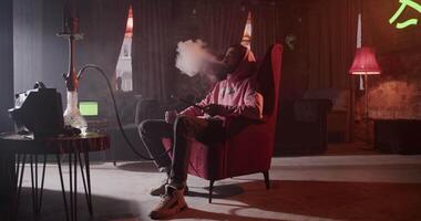 Lounging man with hookah and whiskey in bar video