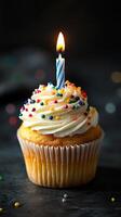 Celebratory cupcake with candle and colorful sprinkles for a special occasion photo