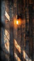 Rustic light fixture casts warm glow against wooden wall in cozy indoor setting photo