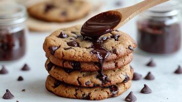 Delicious chocolate chip cookies with melted chocolate drizzle on top and chocolate chips around photo
