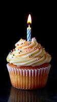 Celebratory cupcake with candle and colorful sprinkles for a special occasion photo