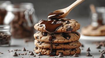 Delicious chocolate chip cookies with melted chocolate drizzle on top and chocolate chips around photo
