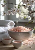 Relaxing spa setting with pink bath salts and blooming flowers in a serene environment photo