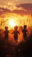Children running towards a sunset in a grassy field during golden hour photo