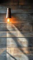 Rustic light fixture casts warm glow against wooden wall in cozy indoor setting photo