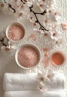 Relaxing spa setting with pink bath salts and blooming flowers in a serene environment photo