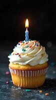 Celebratory cupcake with candle and colorful sprinkles for a special occasion photo