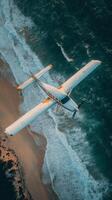 Small airplane flying over a tropical beach with waves and clouds in the background photo