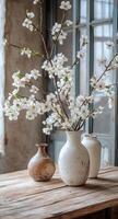Beautiful white flower arrangement in minimalist vases displayed on wooden table photo