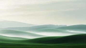 Lush green rolling hills under a soft misty sky in the early morning light photo
