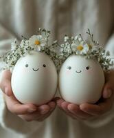 Cute decorated eggs with floral crowns held by a person in soft lighting during spring photo