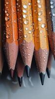 Colorful pencils with water droplets creating an artistic effect on a dark background photo