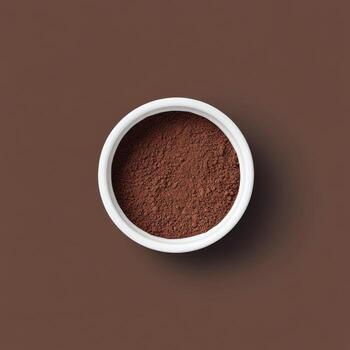 Ground coffee in a small white bowl on a neutral surface for brewing preparation photo