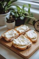Creamy spread on fresh bread near a sunny window with potted plant photo